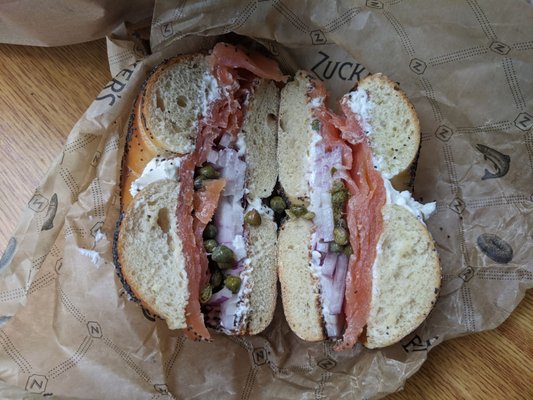 Poppyseed bagel with lox, cream cheese, onion, & capers