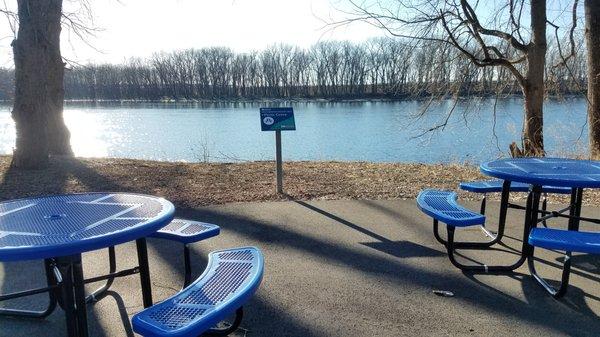 Picnic area with nice new tables. One of them has an open side for a wheelchair.