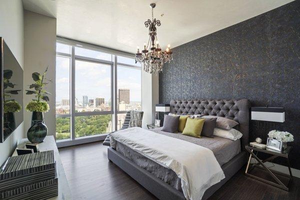 Displaying sophistication and class with a comfy chaise, chandelier, and complementing toss pillows in this bedroom above the city greens.