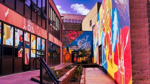 Main entrance of The Wycliff building with a mural that includes a symbol for each business inside!