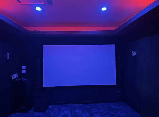 133" 4K projector screen in dedicated theater with Philips Hue lighting system.