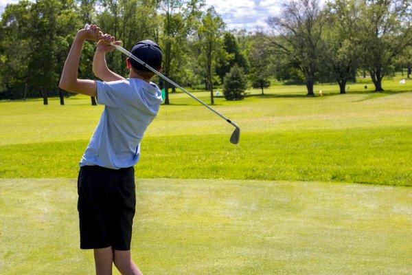 Ridgeway Country Club Junior Golf Academy student hitting shot on golf course