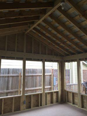 Picture of a screened in porch with a gabled roof with multiple openings for windows to be installed later