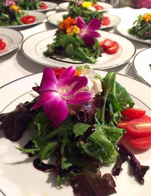 Fresh local greens with a balsamic glaze, grape tomatoes and orchid garnish