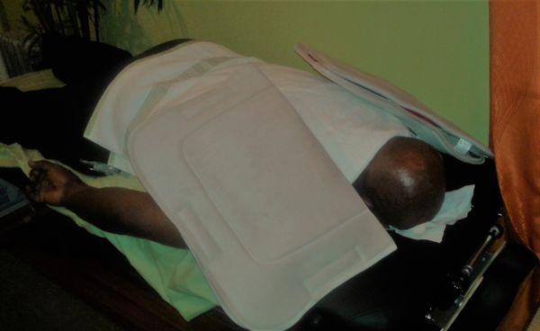 Client receiving Hot pack Bio-freeze back muscle relaxer