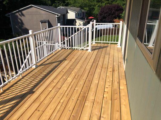 Replaced weather-worn deck with new cedar decking.  Added stairs and aluminum handrail.