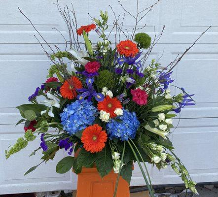 Modern design sympathy arrangement done in masculine colors.