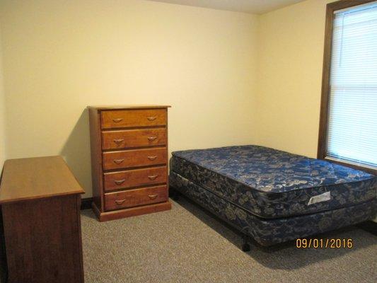 Typical Furnished Bedroom includes a desk, dresser and full size bed.