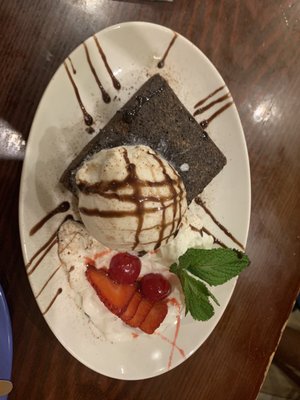 Brownie with chocolate ice cream and strawberries and cream