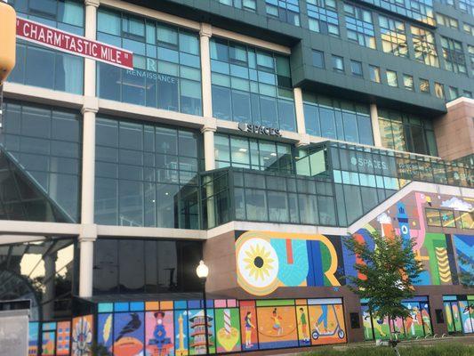 The 'Our Baltimore' Mural backdrop to the famed "Charm'tastic Mile" Street Sign.