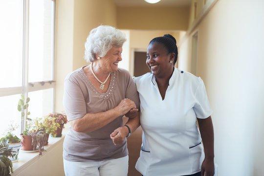 The caregiver is ensuring the client that she won't fall while allowing her to lean on her while walking.