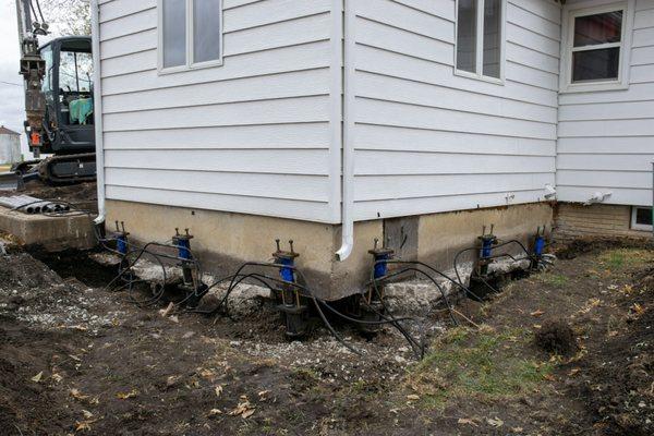 Foundation repair with Helical Piers and a hydraulic lift.