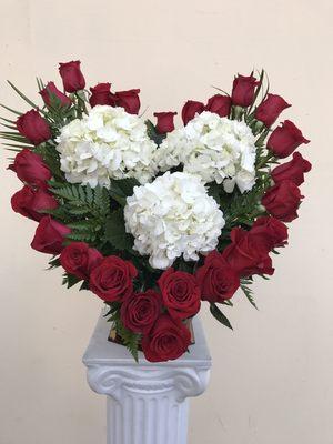 Basket arrangement. 24 red roses in heart shape with 3 hydrangeas in center.   Please call for pricing details.