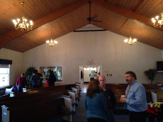 Main sanctuary of church with Pastor Paul on the right in blue.