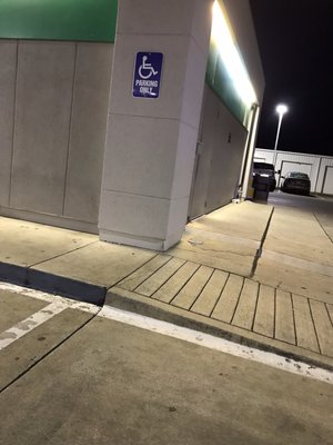 Handicap/Wheelchair ramp at end of long/narrow sidewalk.