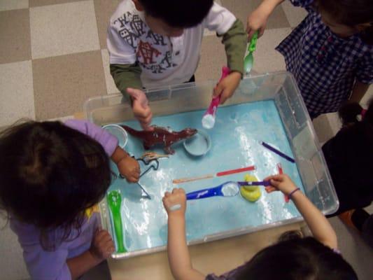 Sensory table with Oobleck, tools, and dinos