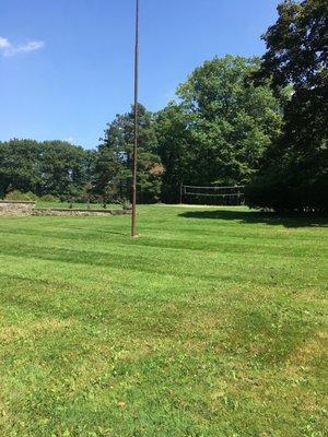 Open clearing on the grounds near Bolton house behind legacy village, volleyball court there too with lots of weeds growing