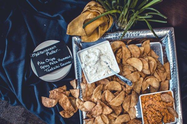 Appetizer featuring fresh pita chips, hummus, and dip.