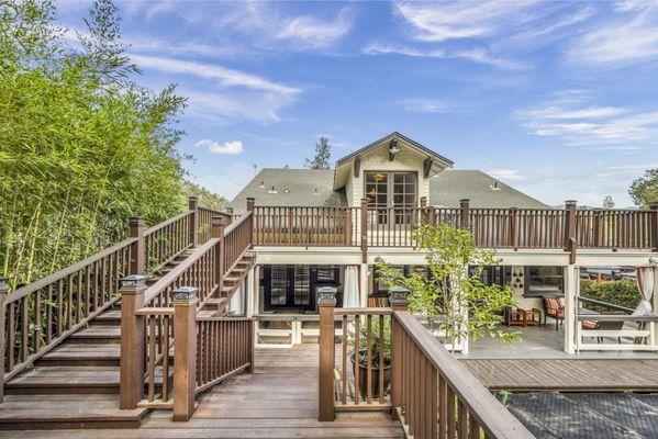 Back of craftsman-style property with view of back porch entrance and back deck and several places to sit.