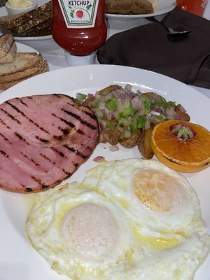 Ham and steak with eggs along with potatoes