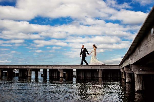 Bride and groom walk along a dock in Manahawkin, NJ on their wedding day.