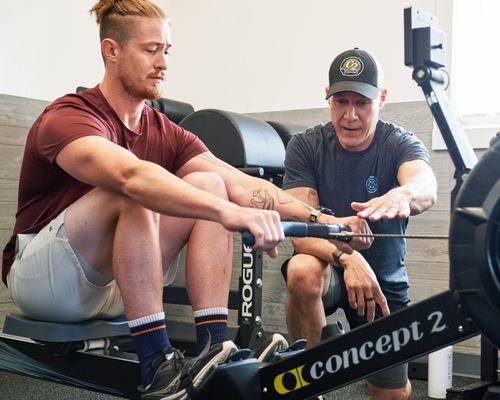 Athlete working with indoor rowing coach, Steve Tague, at Rowed to Fitness in Bend OR.