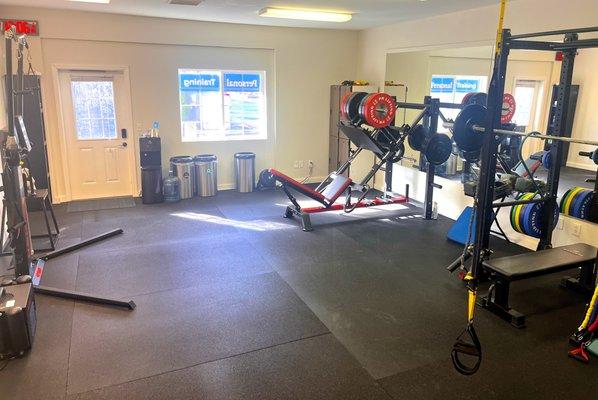 Main workout space with kettlebells, Keiser functional machine, TRX, and leg press.