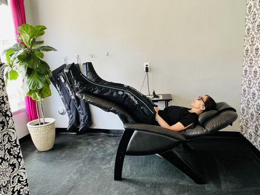 Enjoy Therabody compression boots while resting in our zero gravity chair.