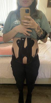 After an adjustment meiling helped me with KT tape to support my 3rd trimester belly