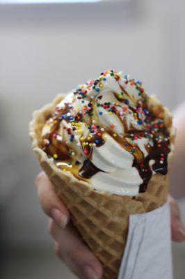 HOMEMADE waffle cone with vanilla soft serve ice cream, topped with chocolate drizzle and sprinkles! YUM