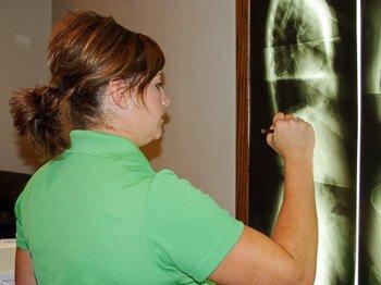 Dr. Chelsa examining a patient's x-ray