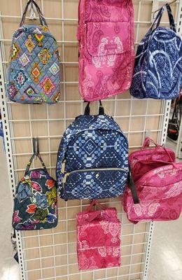 A selection of Vera Bradley lunch sacks and backpacks.