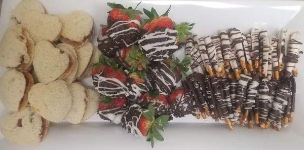 Chocolate covered pretzels and strawberries with heart shaped peanut butter and jelly