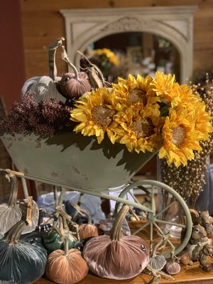 Wheelbarrow display with sunflowers and velvet pumpkins.