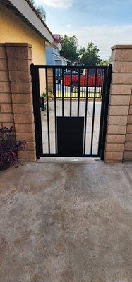 After. Inside side gate with doggy door closed and combo lock on both sides.