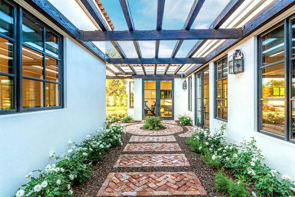 Charming walkway using reclaimed bricks and lined with soft plantings.