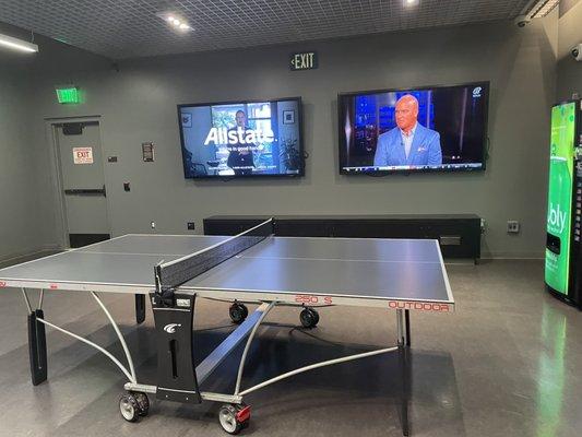 Another Ping pong table in the back with a pair of larger TVs and a few more vending machines