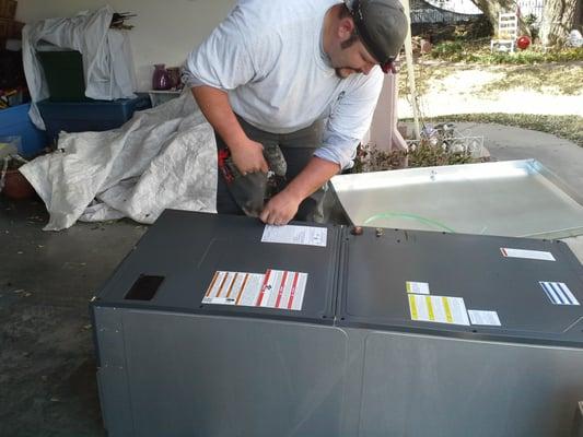 Travis preps an indoor air conditioning unit for installation.