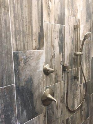 The allure of antique wood and the natural charm of stone with using this tile as an accent wall. 2018 Parade Home Custom Shower .