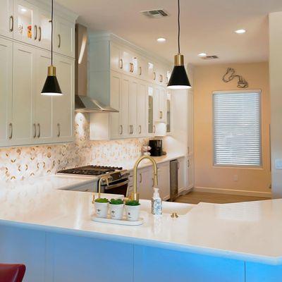 The combination of white cabinets and excellent lighting makes this kitchen the perfect place for cooking and sharing.