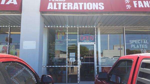 In front of the alteration shop, bring clothes in get ready to try on.