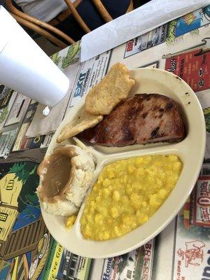 Ham with creamed corn and mashed potatoes. The corn bread is a thin fried bread.