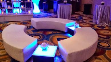 Curved ottoman with illuminated side tables.