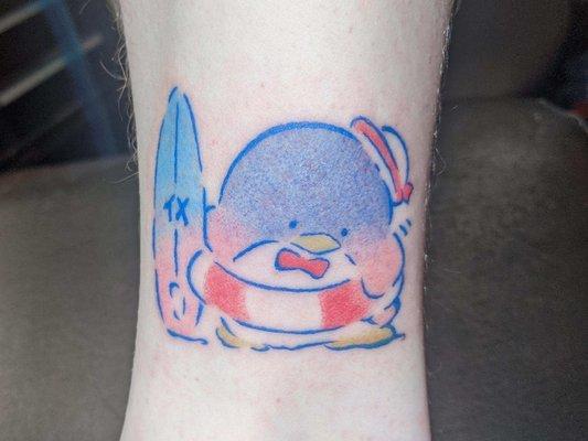 An absolutely adorable little penguin ready for the beach tattoo.