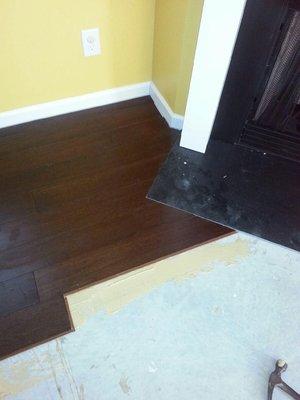 Angle cuts around fireplace with bamboo flooring.