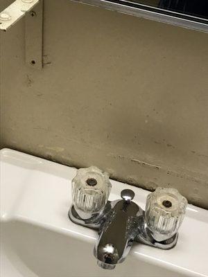 Shelf bracket with no shelf . Sink not bolted to wall