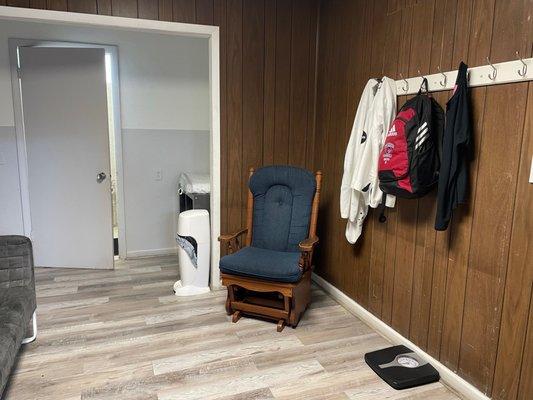 Rocker with baby changing table in lounge area in front of womens bathroom