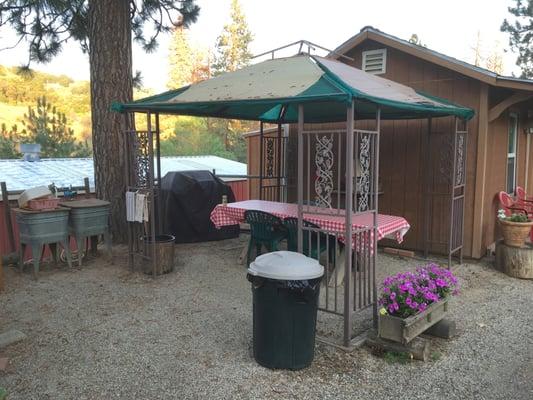 Pleasant shaded outdoor dining area. Tub sinks add a old fashioned country touch. Potted plants & flowers blooming everywhere.