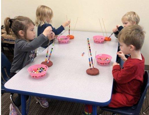 Learning those fine motor skills.  PlayDoh, skewers and beads.  This is also a great way to work on learning patterns.