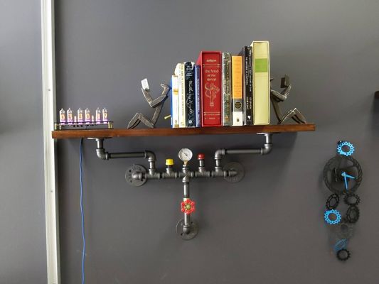 Steampunk shelf, nixie tube clock, bookends made of railroad spikes and some books for ambience.